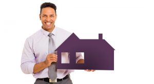 Man holding cutout of house