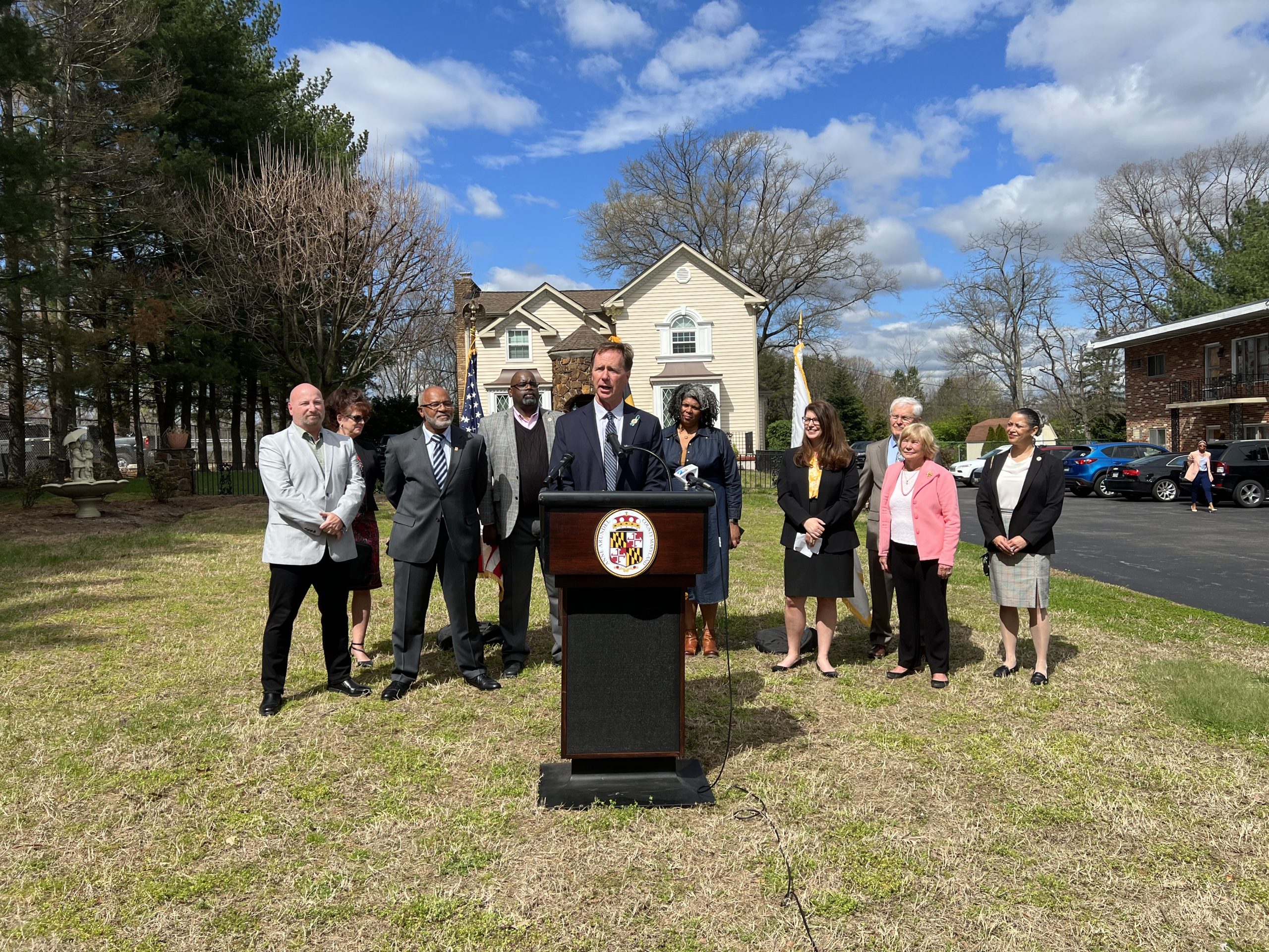 County Executive at the podium surrounded by other community leaders